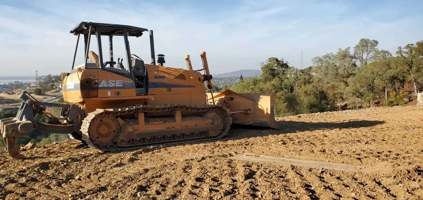 A dozer shaping a building pad in compacted lifts