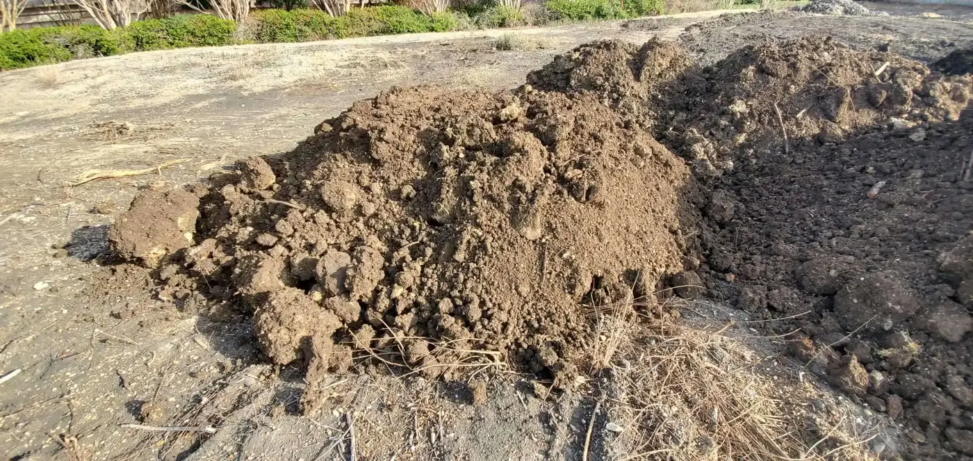 A tipped load of dark fill spread out on a pad